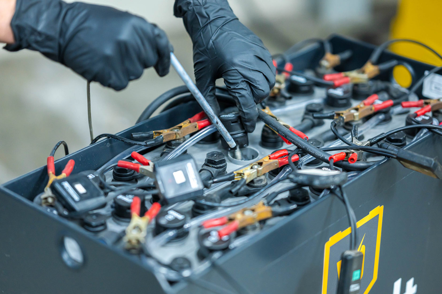 Handen met handschoenen om temperatuur te meten in accu cellen